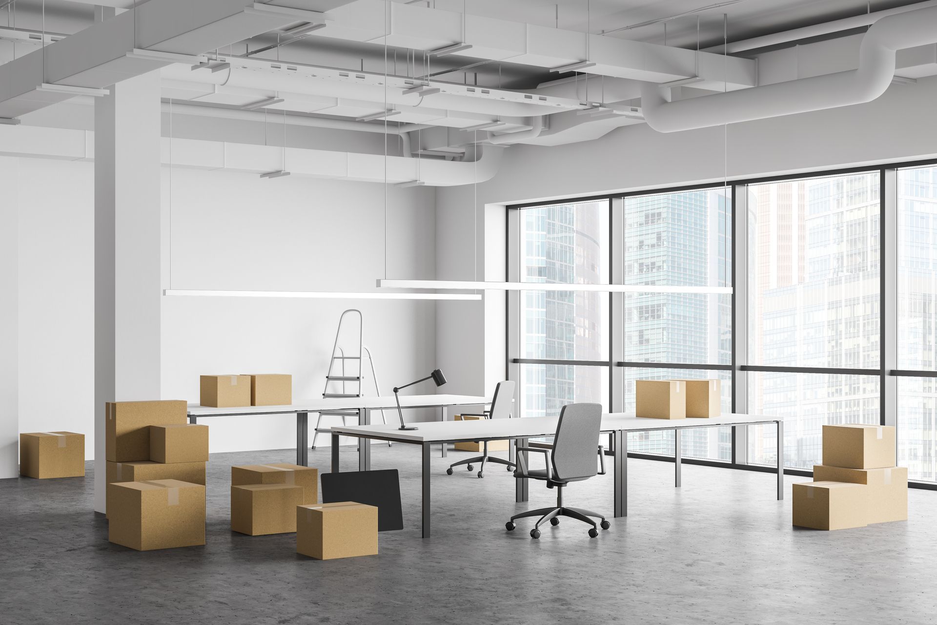 Bureau vide avec des cartons de déménagement, des bureaux et une échelle près de grandes fenêtres.