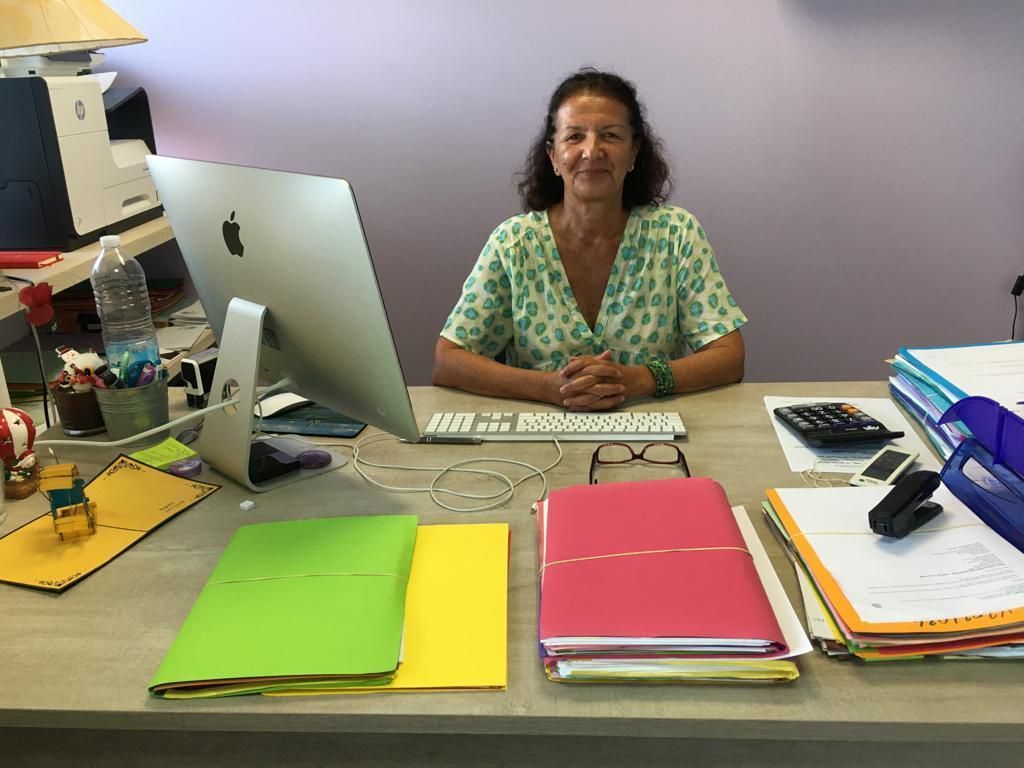 Une femme derrière son bureau.