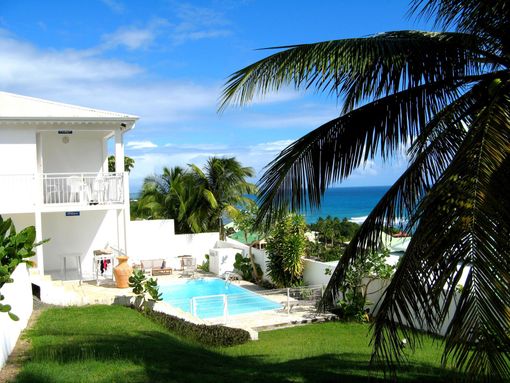 Villa blanche, piscine et palmiers avec vue sur l'océan