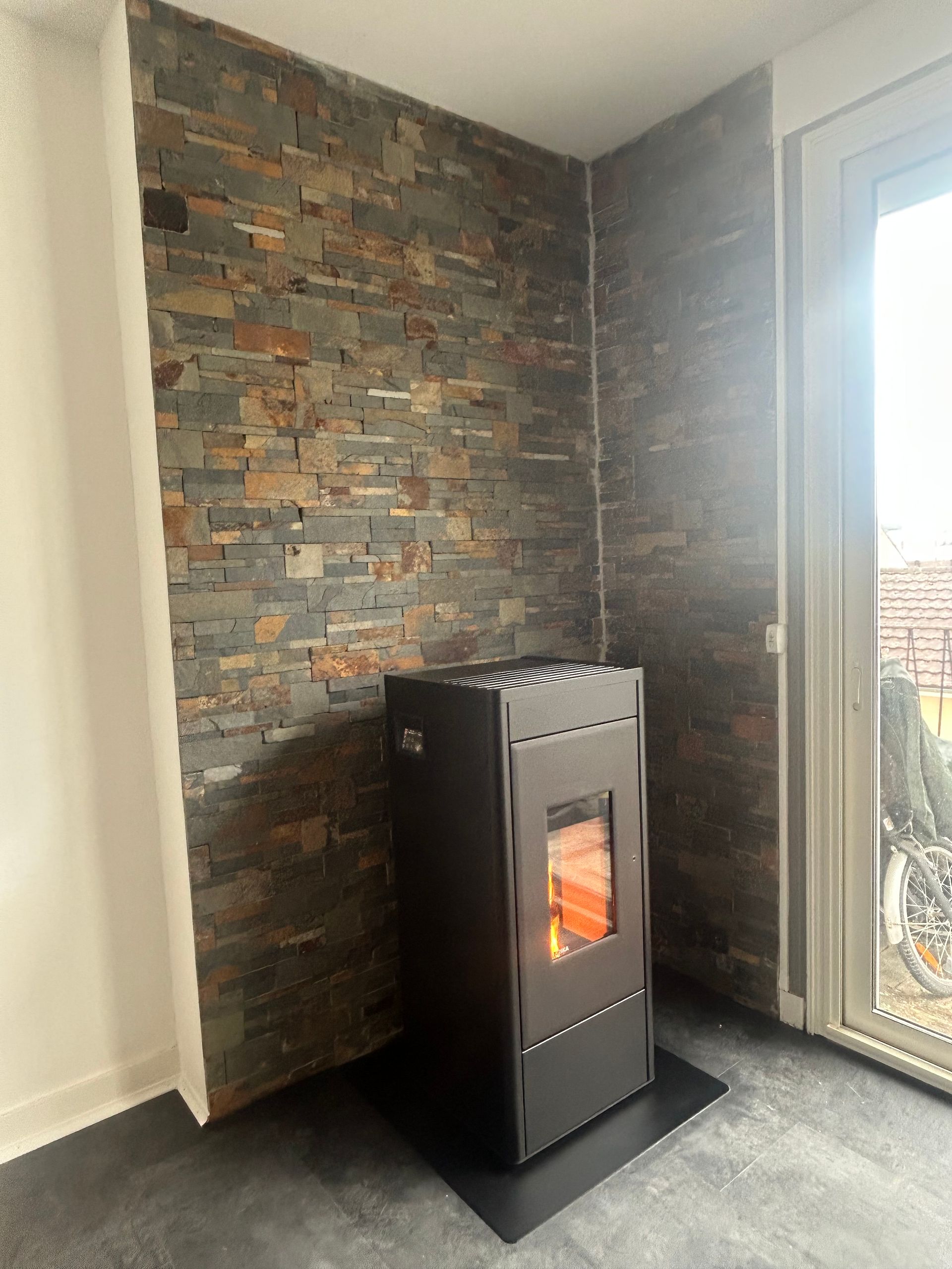 Poêle à bois dans l'angle d'un mur de pierre