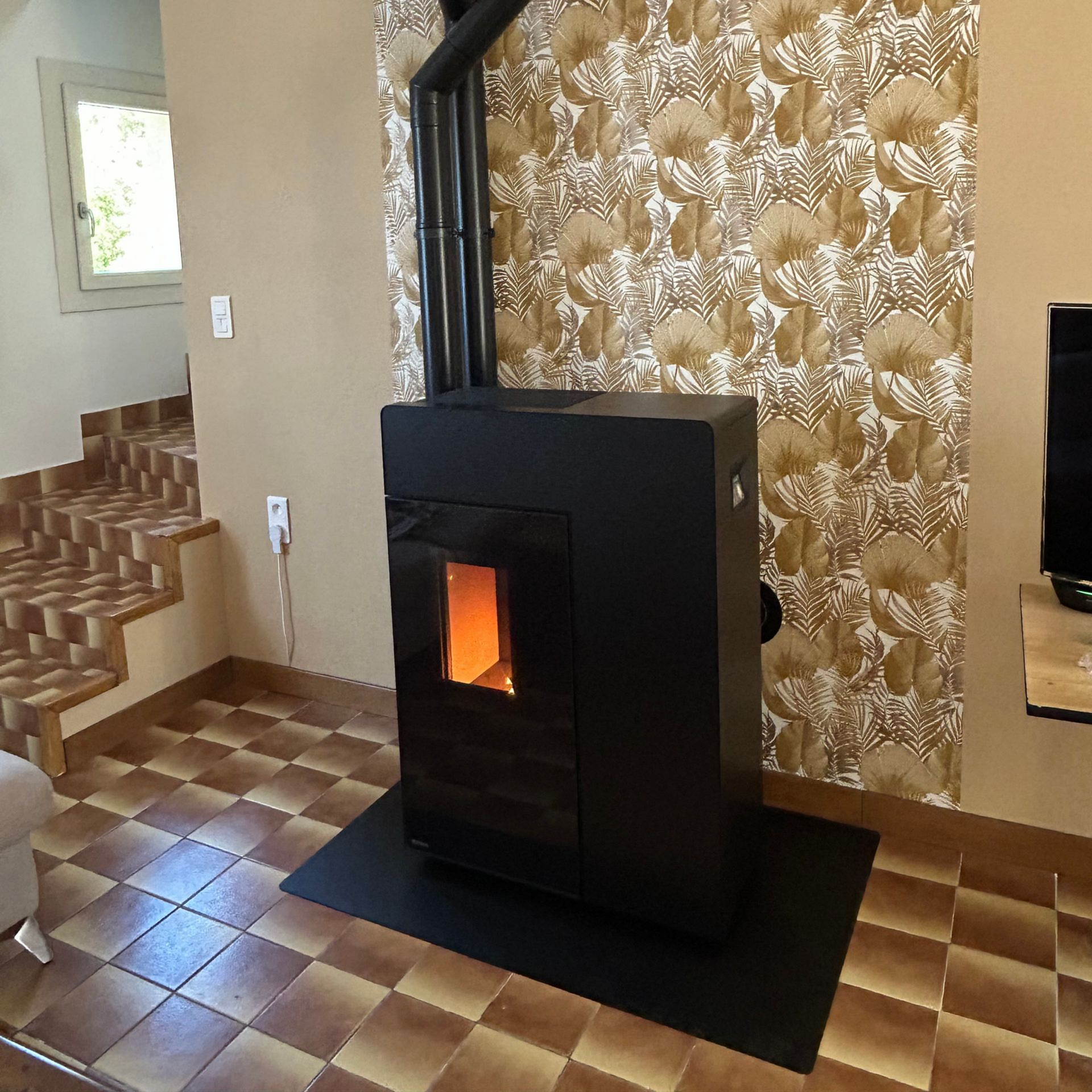 Poêle mixte installé près d'une fenêtre