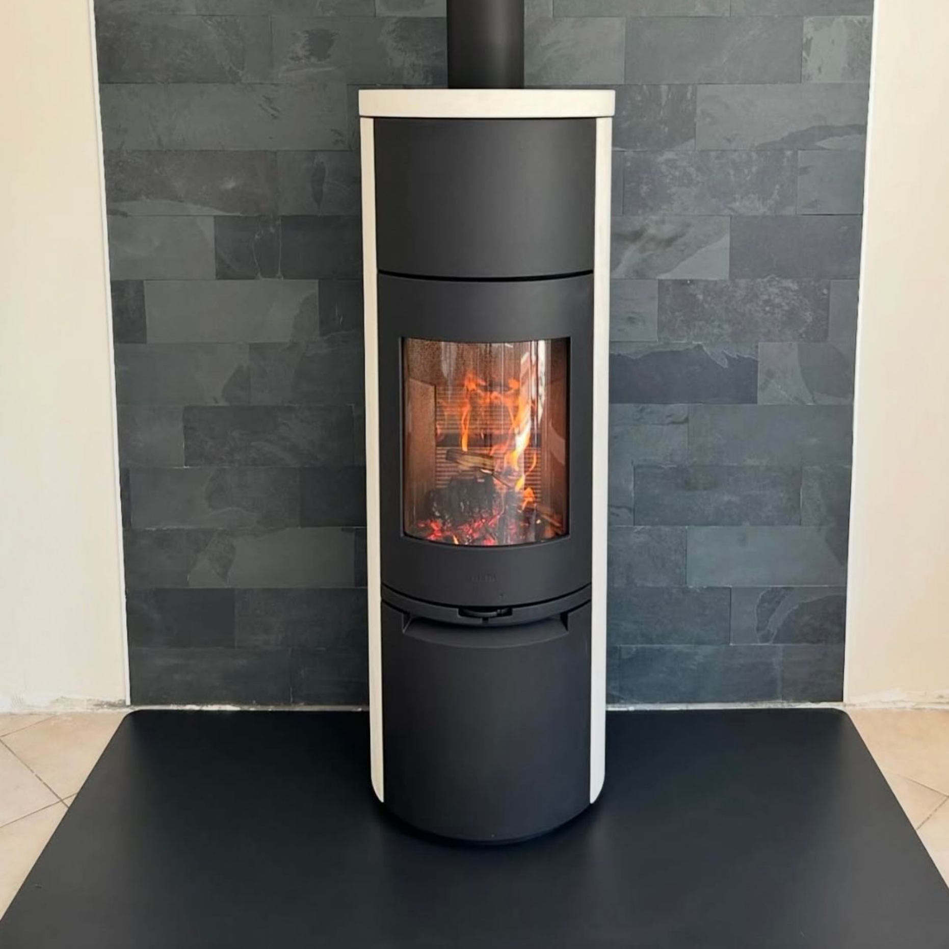 Poêles à bois cylindriques et mur vert