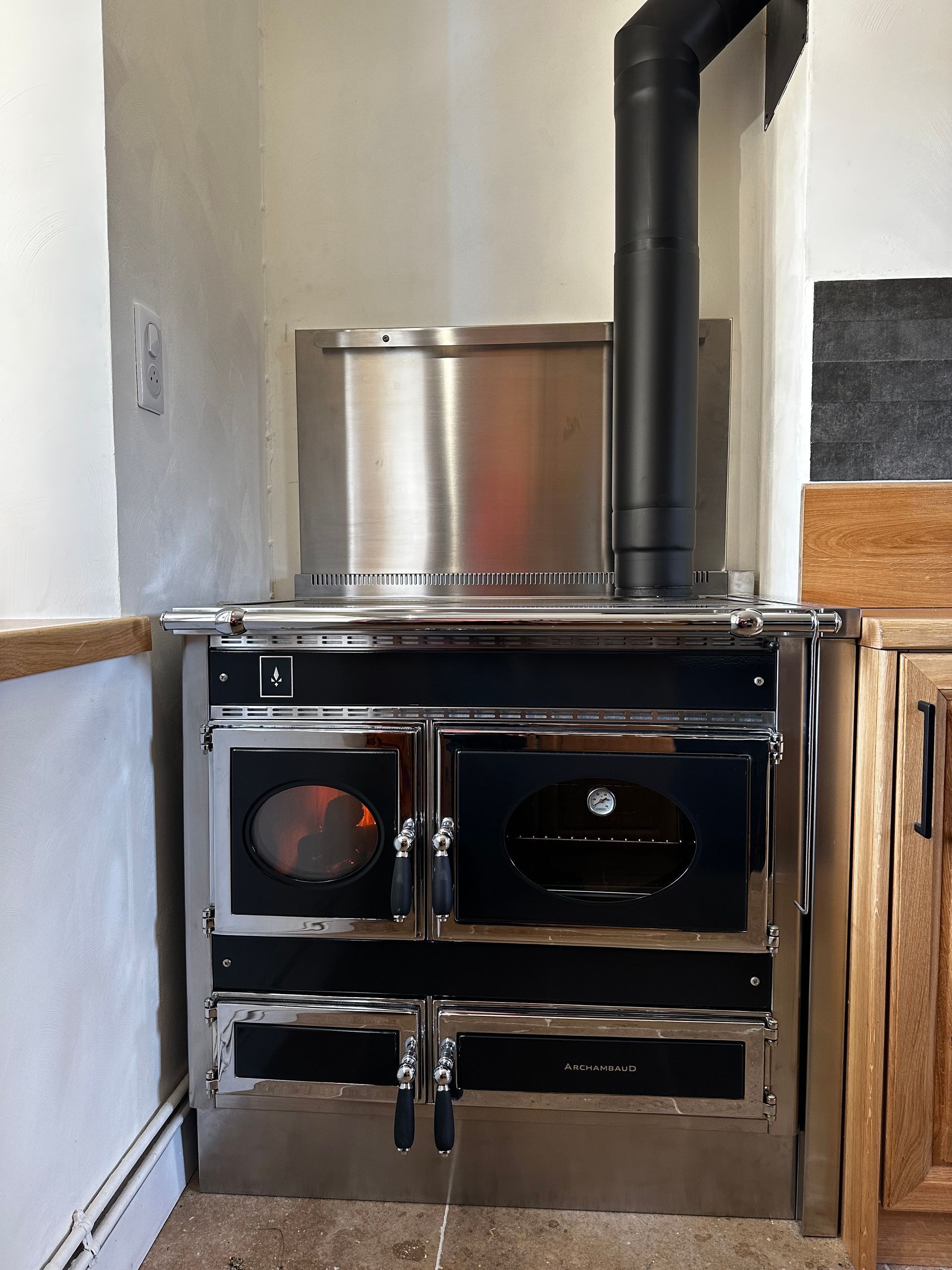 Une cuisinière en acier inoxydable avec des fours et une cheminée dans une cuisine