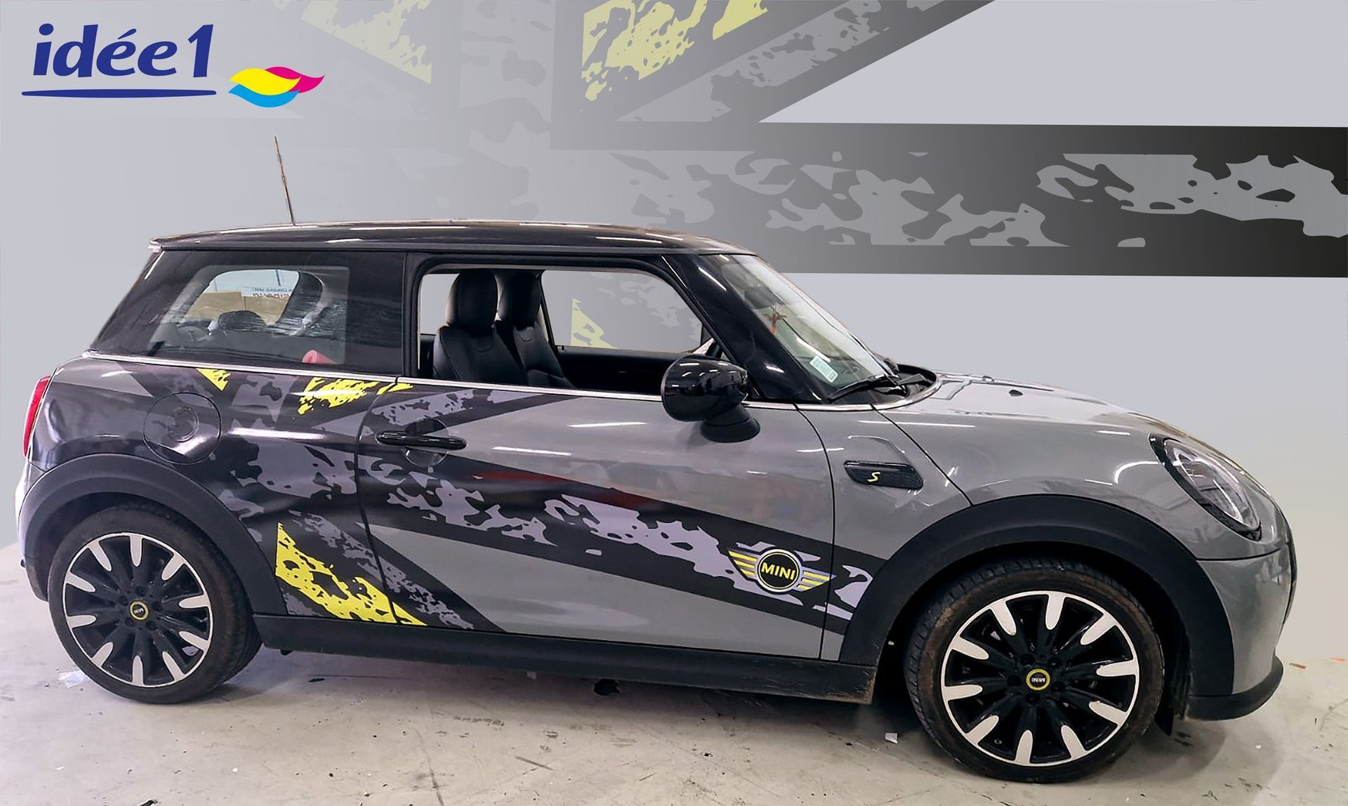 Voiture grise avec des accents noirs et des graphismes décoratifs.