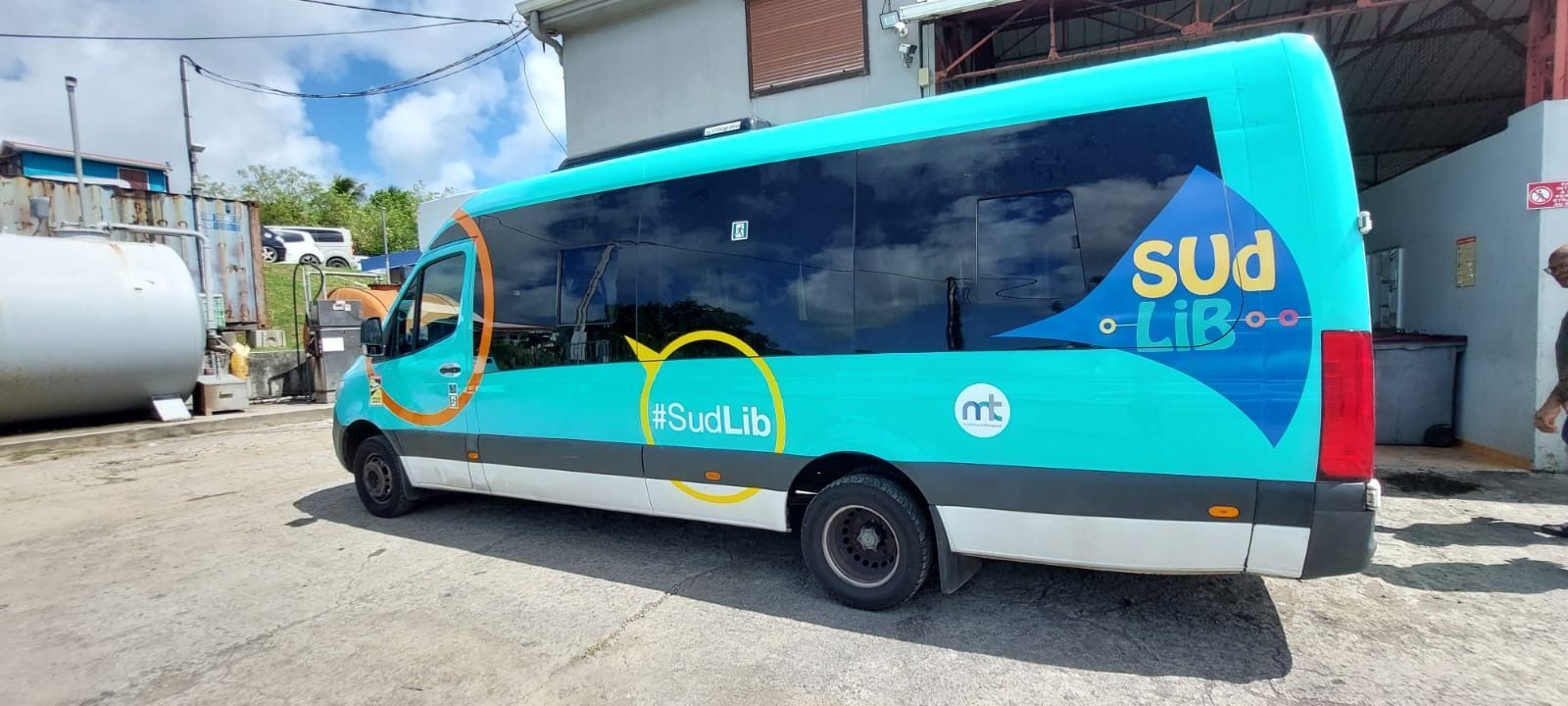 Un minibus turquoise avec l'inscription Sud Lib.