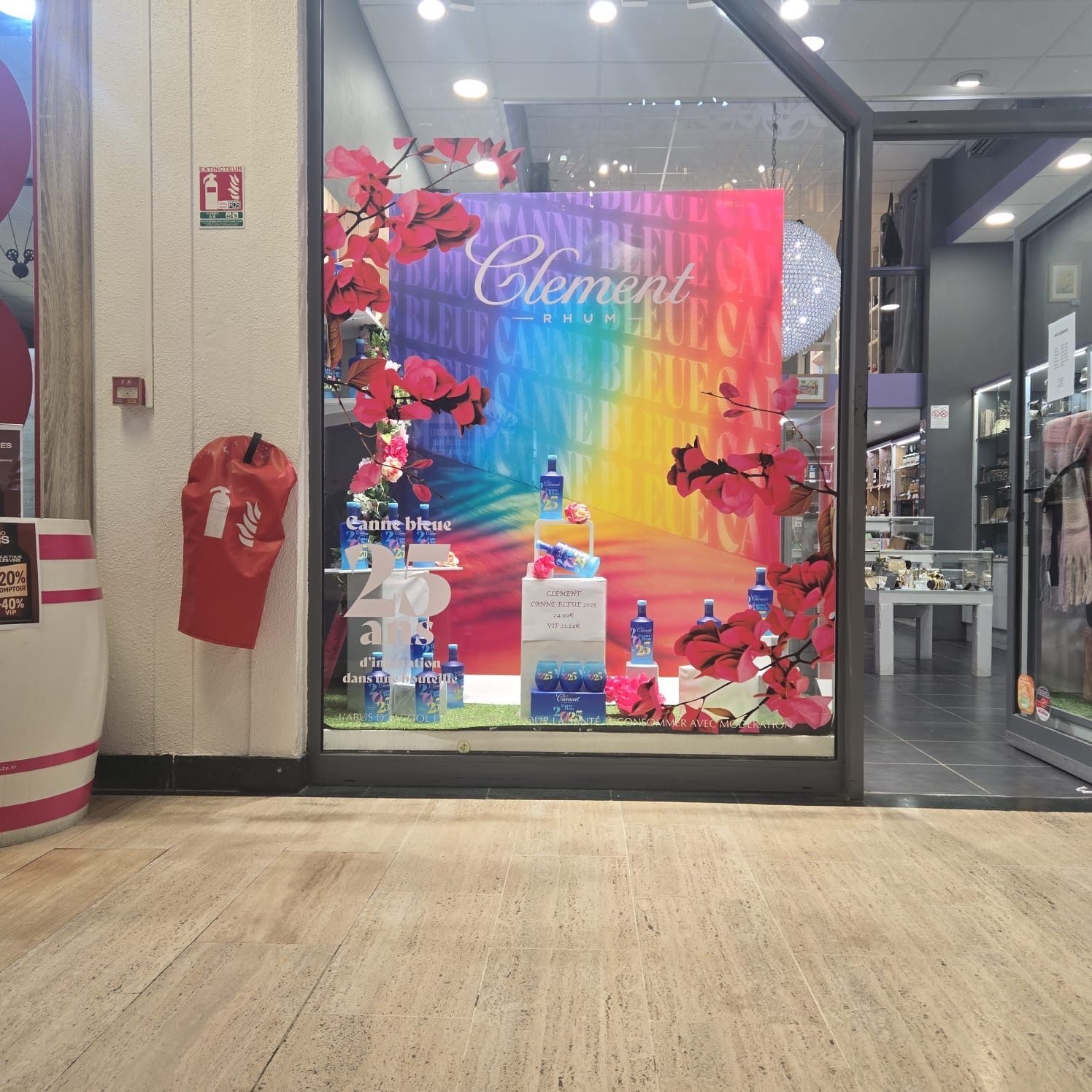 Vitrine avec fond arc-en-ciel, fleurs et produits.