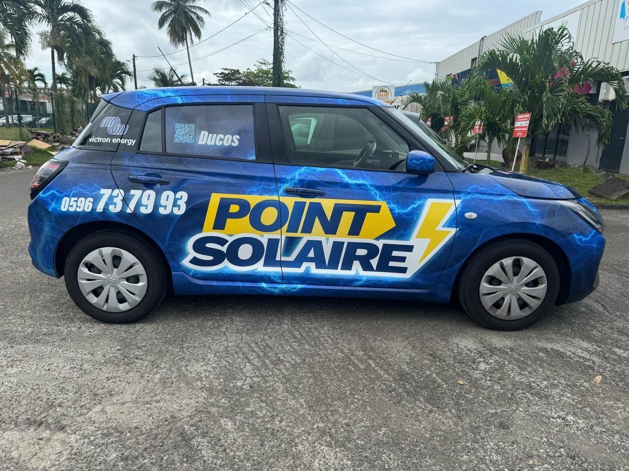 Voiture bleue avec l'inscription POINT SOLAIRE.