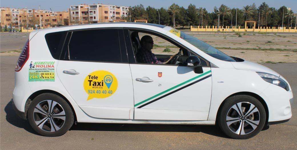 Coche taxi de color blanco, puerta abierta, conductor dentro, con logo