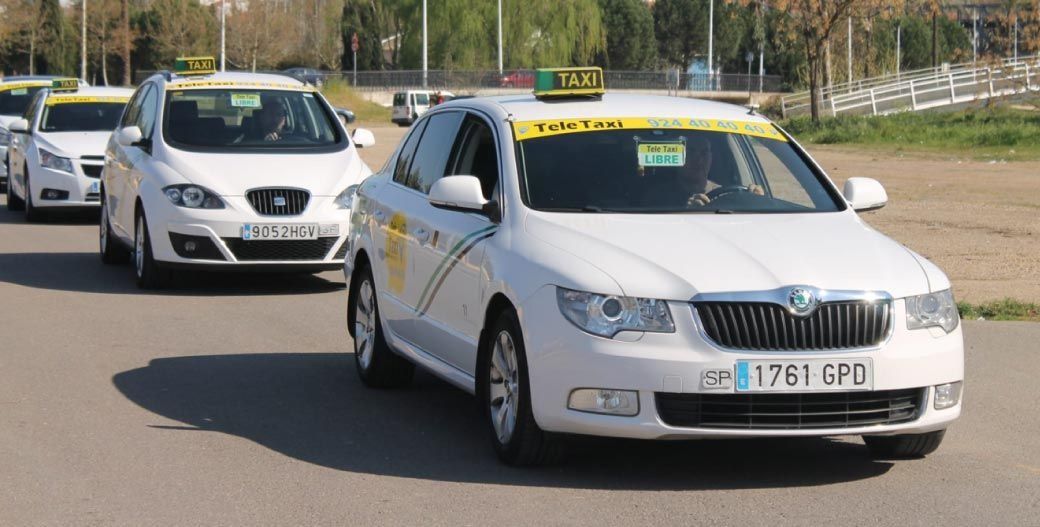 Taxis blancos circulando por la carretera; día soleado. El coche delantero tiene matrícula 1761 GPC.