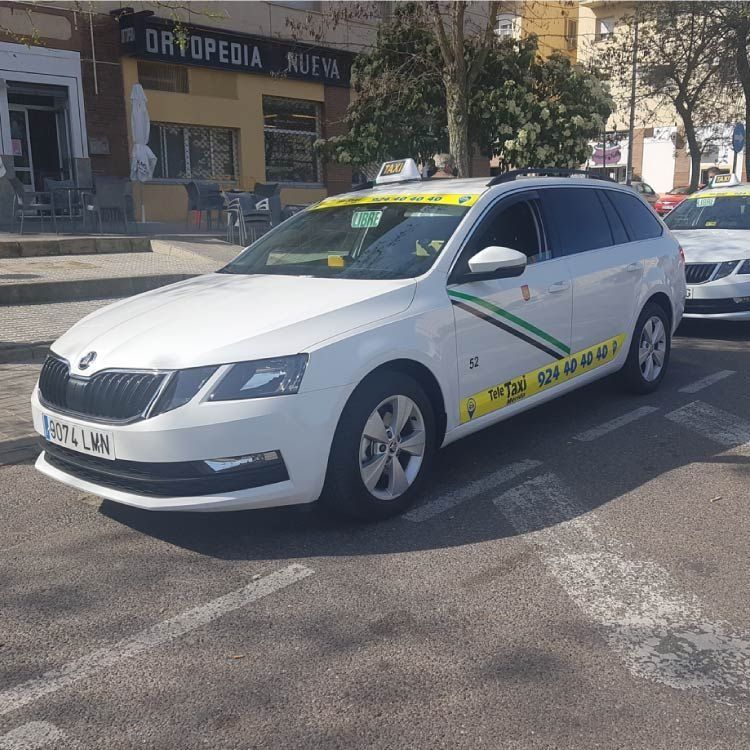 Taxi blanco estacionado en una calle;