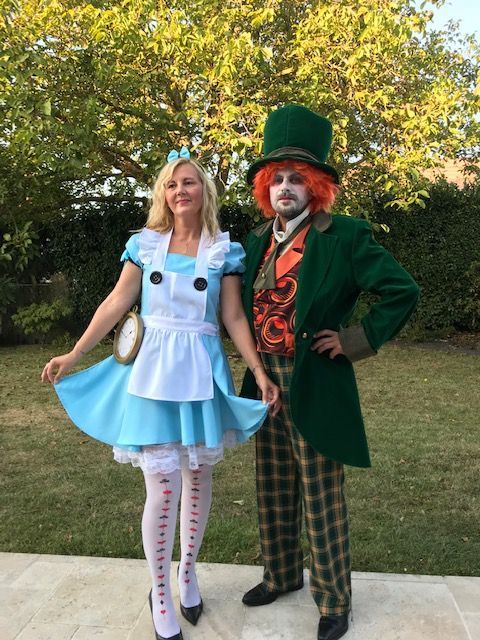 Une femme blonde avec une robe bleue et un homme avec un costume