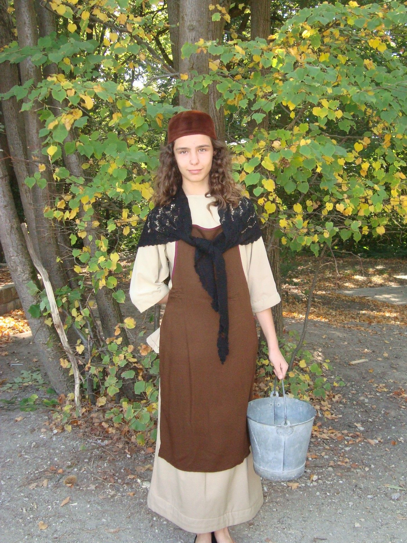 Une femme avec une robe brune et qui porte un sceau