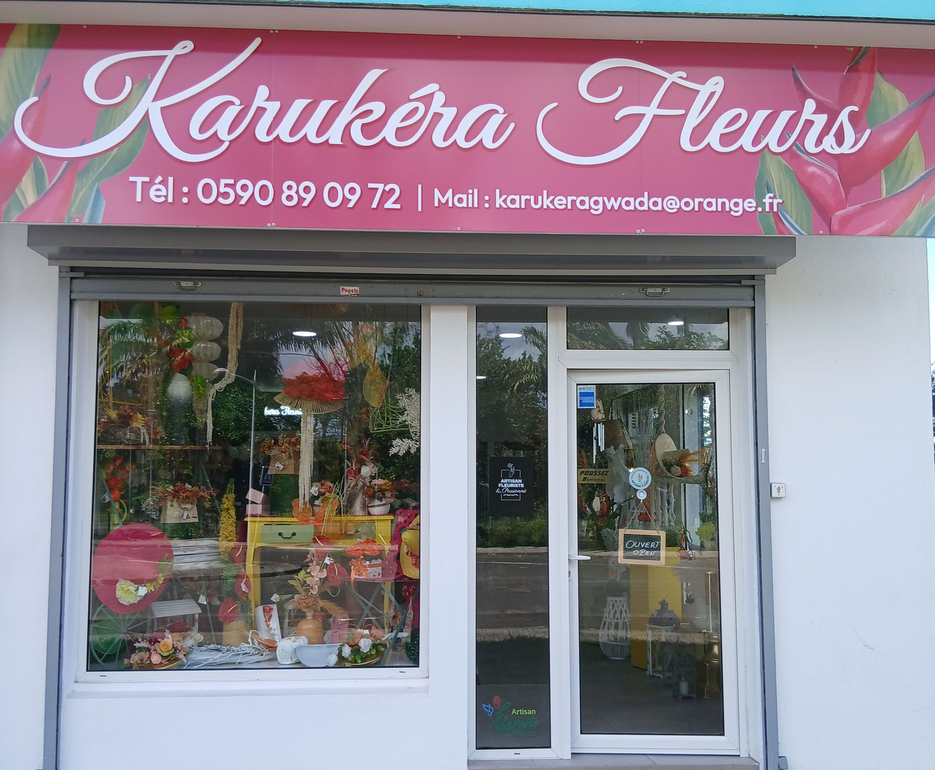 Bouquet de roses rouges éclatantes, enveloppé dans du papier noir avec des bordures dorées.