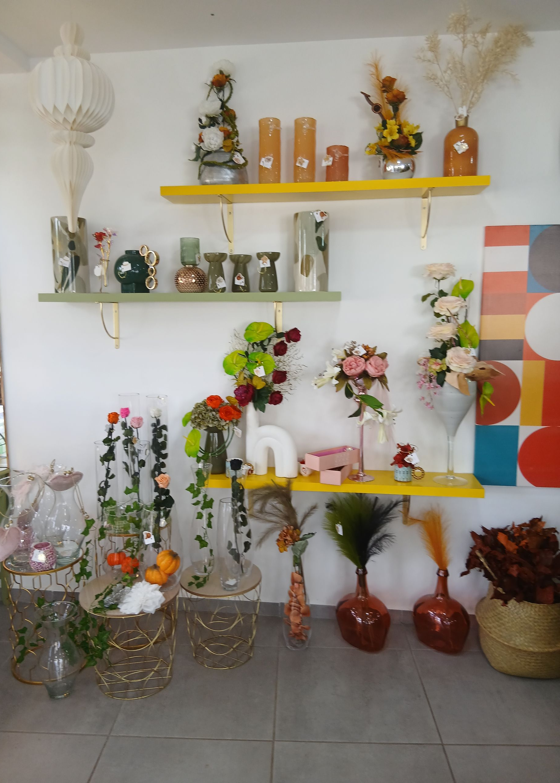 Rose rougeoyante sous un dôme de verre illuminé de guirlandes lumineuses, sur un socle noir.