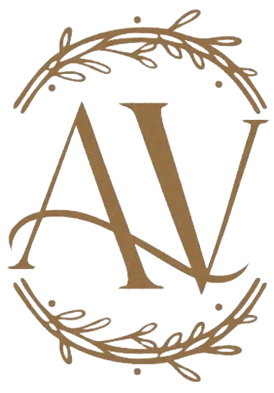 Logotipo con monograma dorado “AV” en una corona circular de hojas sobre fondo blanco.