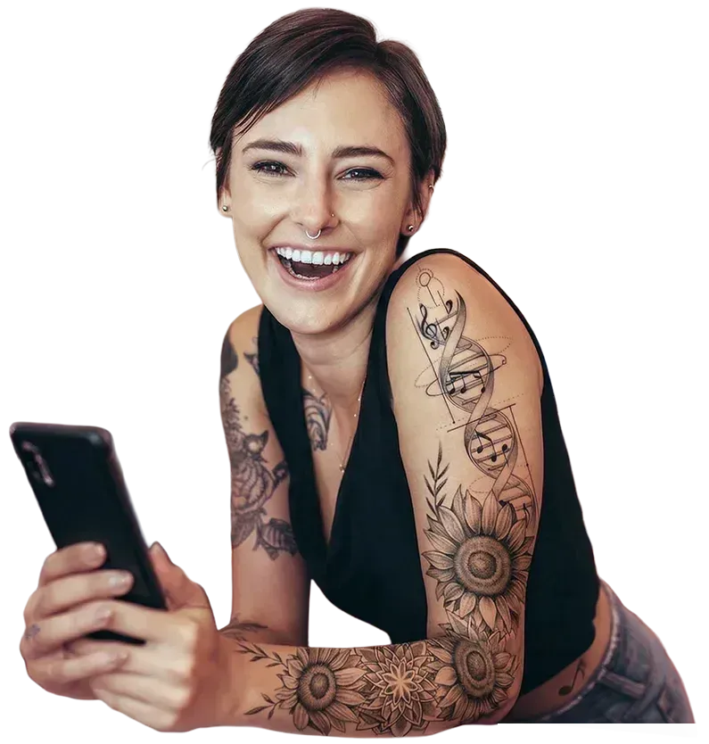 Eine lächelnde Person hält ein Smartphone in der Hand und zeigt kunstvolle Tattoos mit Blumen- und DNA-Motiven auf ihrem Arm.
