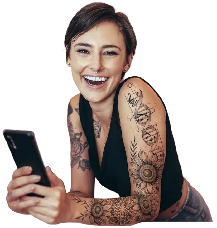 Eine lächelnde Person hält ein Smartphone in der Hand und zeigt kunstvolle Tattoos mit Blumen- und DNA-Motiven auf ihrem Arm.