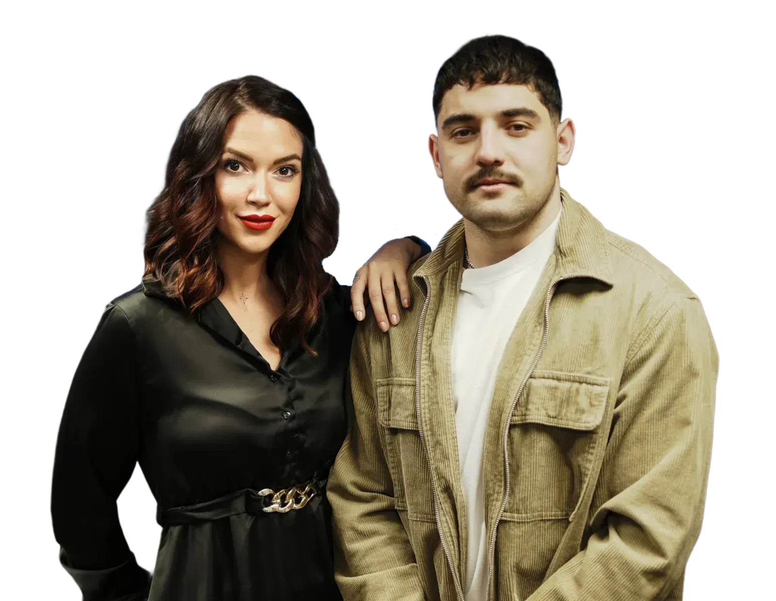 Eine Person steht neben einer Person in einer hellbraunen Jacke; beide posieren vor einem weißen Hintergrund.