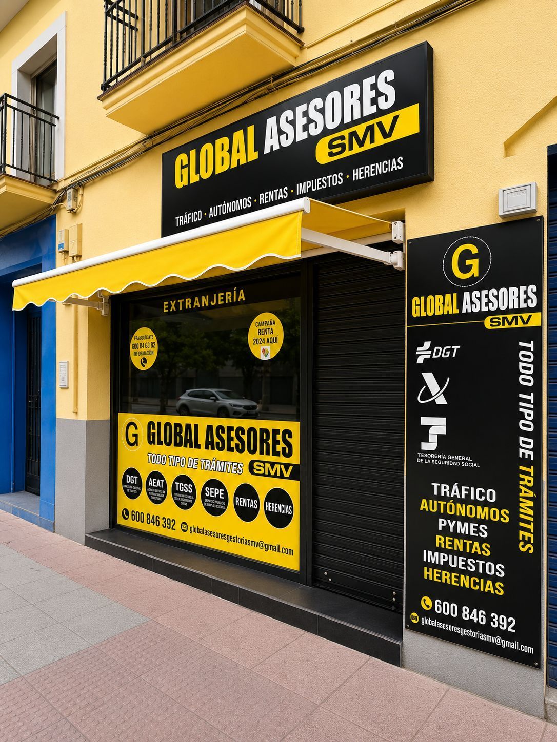 Fachada amarilla y negra de Global Asesores con un gran letrero y la lista de servicios empresariales.