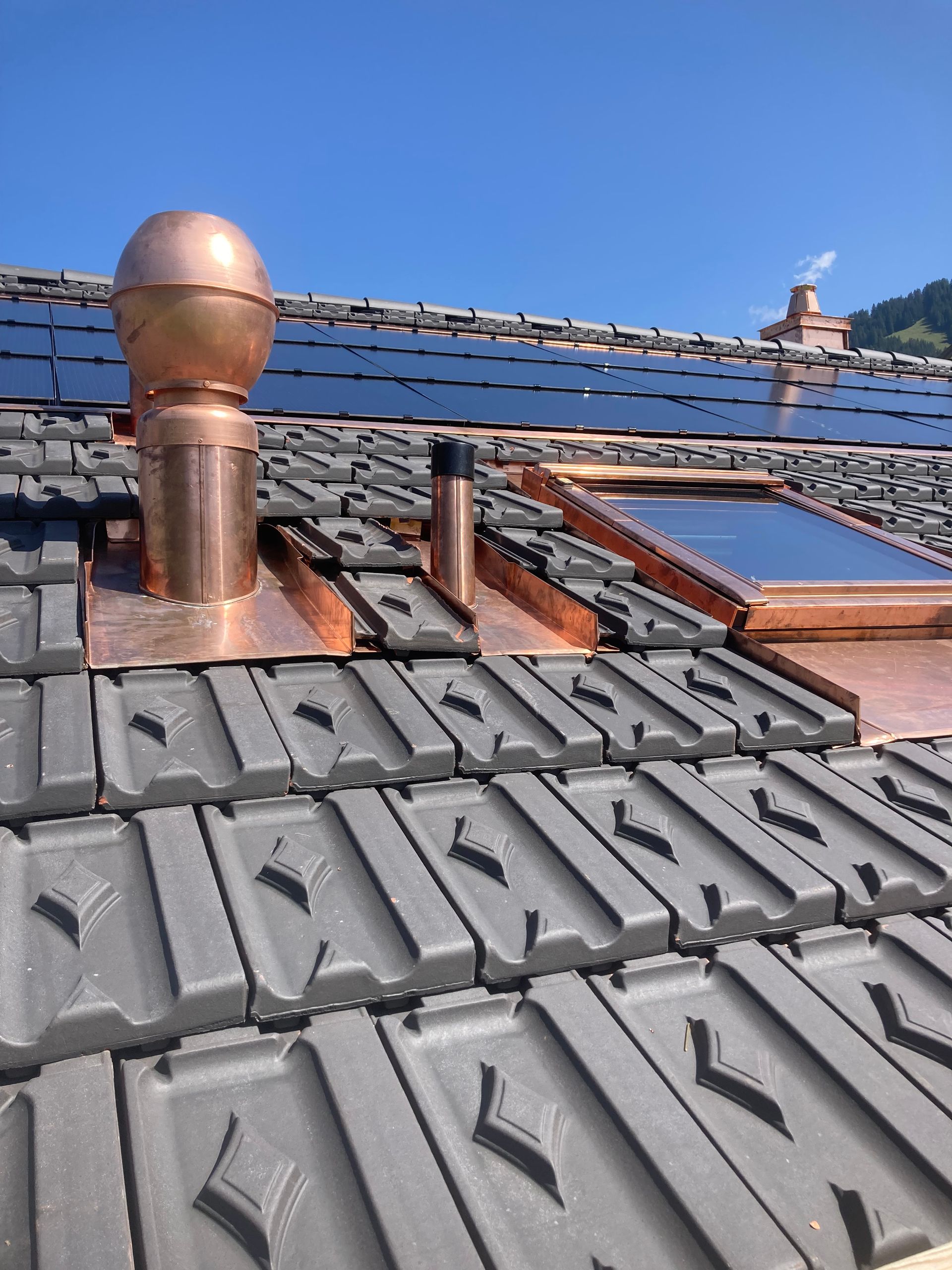 A man is sitting on top of a metal roof.