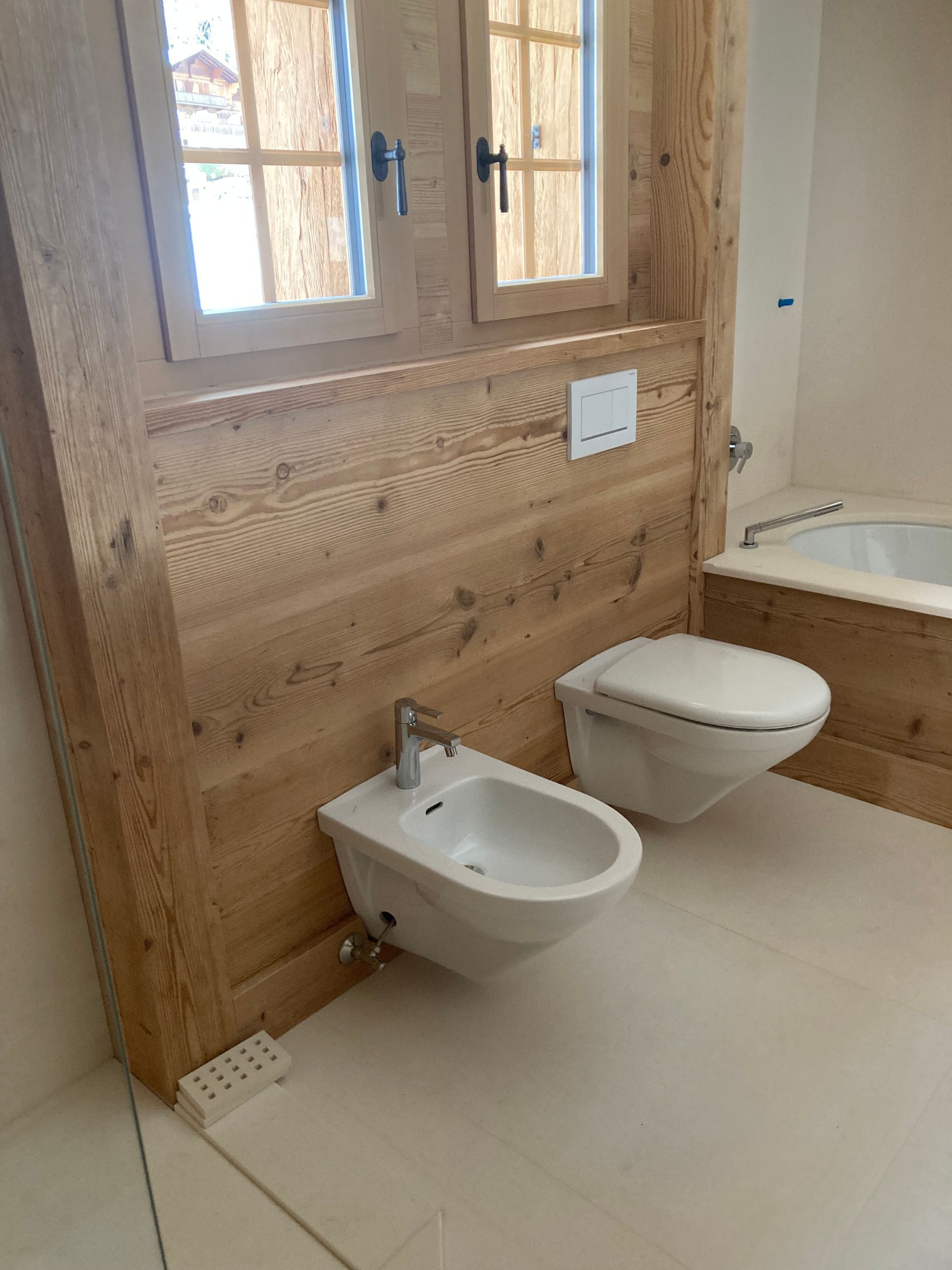 Une salle de bain avec deux toilettes, un bidet et une baignoire - Thierry Schopfer Sàrl