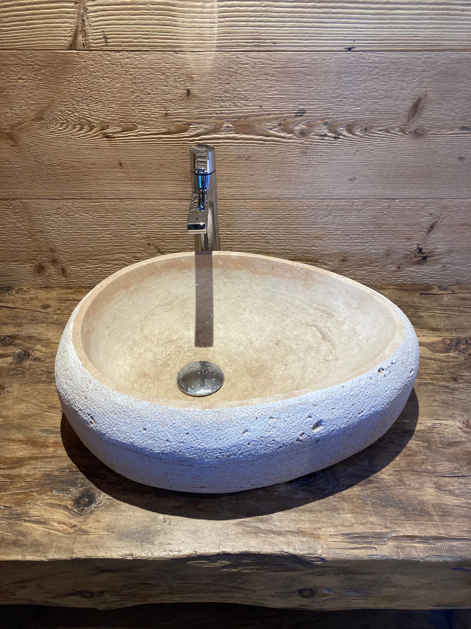 Un évier en pierre avec un robinet sur un comptoir en bois - Thierry Schopfer Sàrl