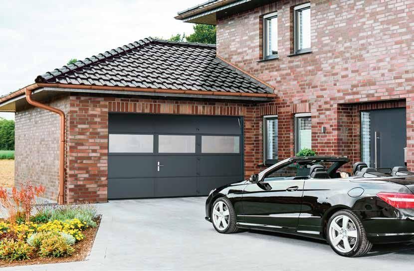 Un véhicule coupé noir devant la porte d'un garage.