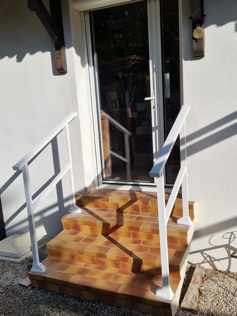 Garde-corps d'un escalier menant à une porte.