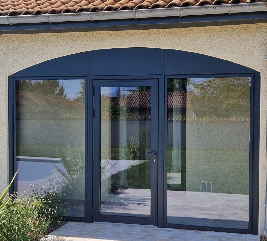 Une porte vitrée au mileu de deux grande vitre 2.