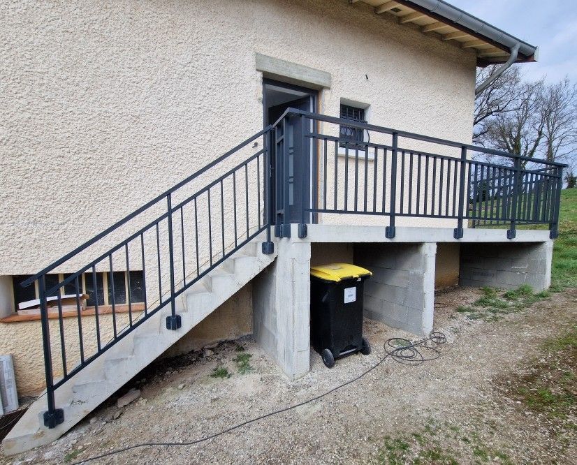Un garde-corps sur un escalier et contours de maison surélevés.