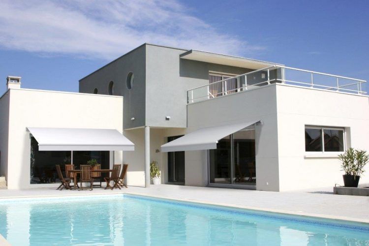 Une maison devant une piscine.