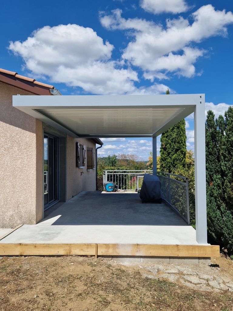Pergola gris clais sur une terrasse de maison.