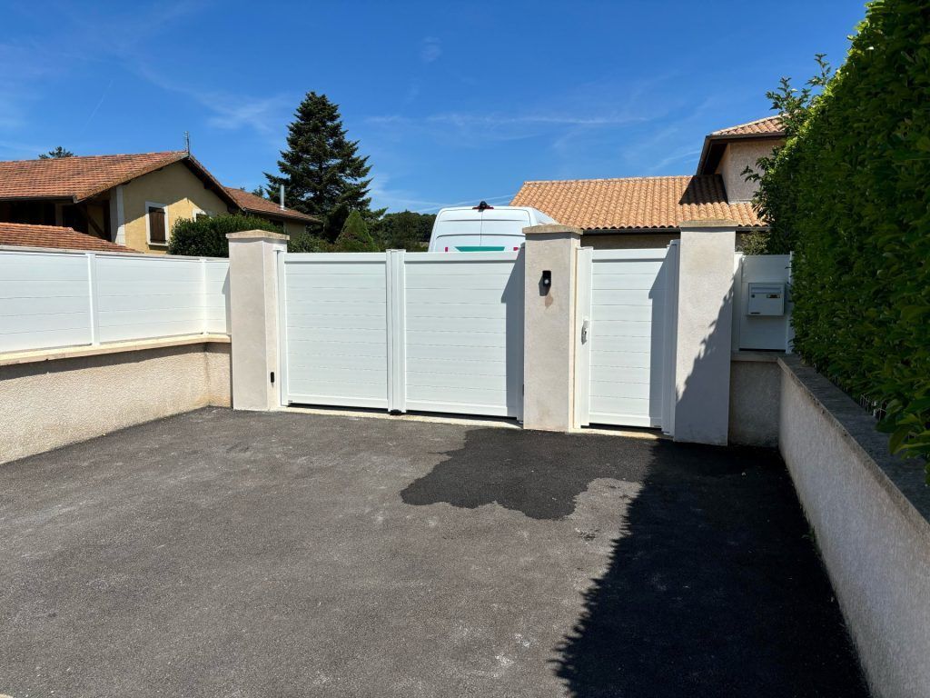 Un portail et portillon blanc fermés.