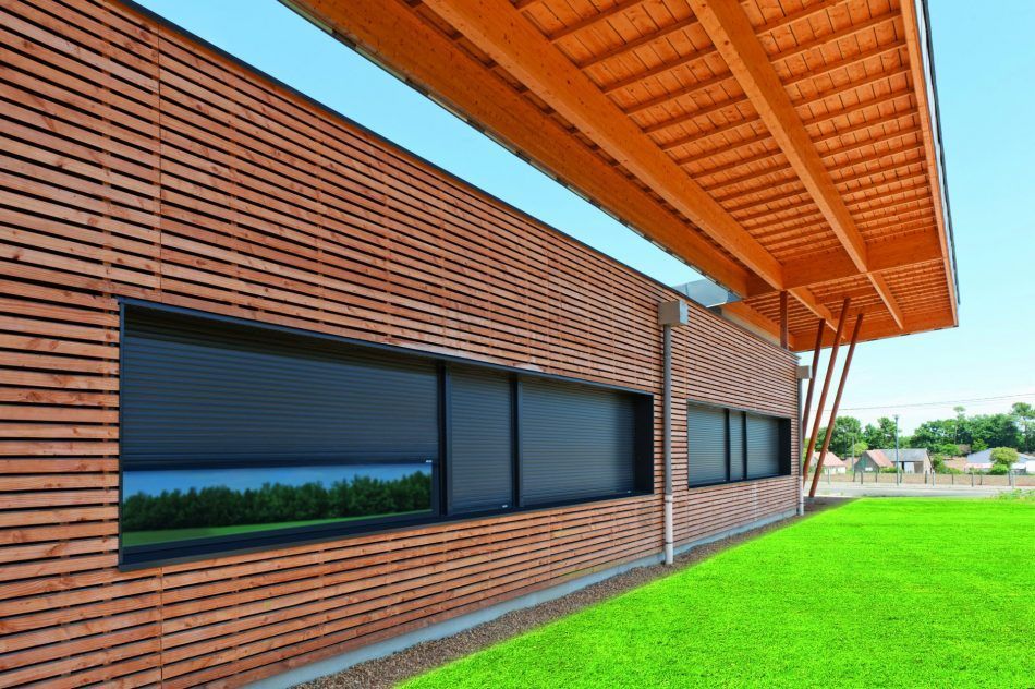 Grand bâtiment avec bardage en bois.