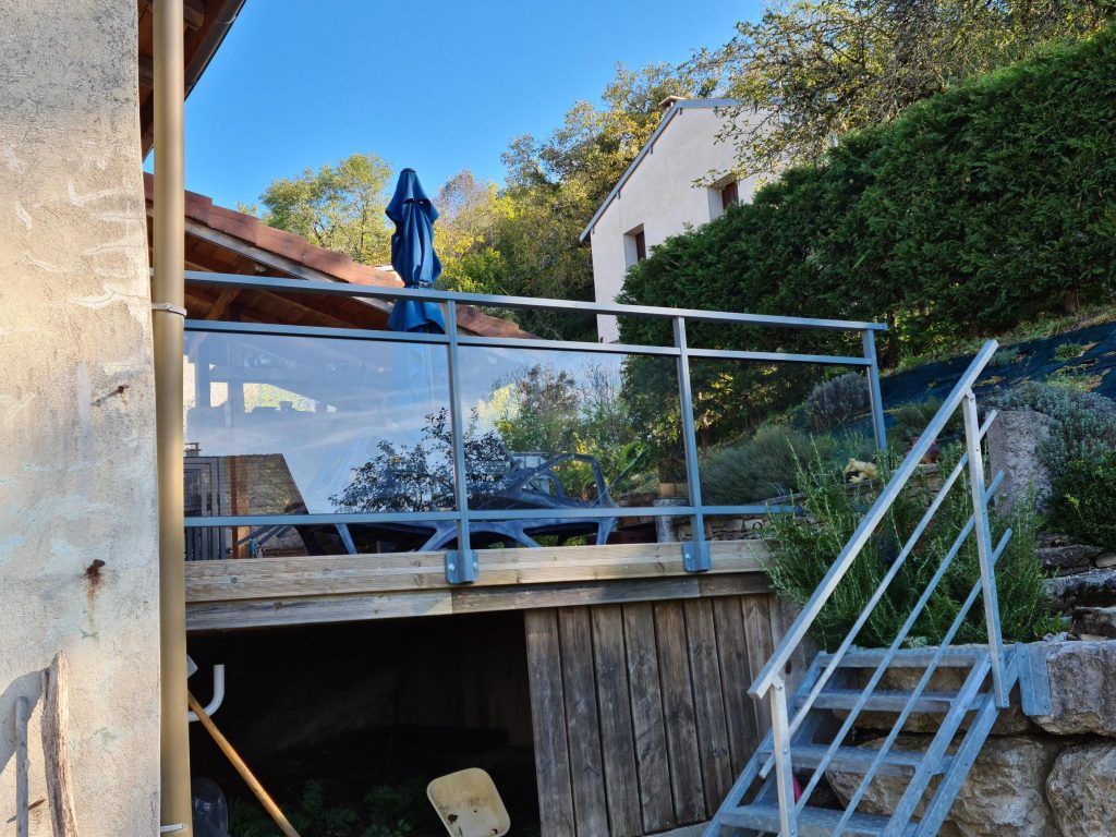 Garde-corps d'une terrasse surélevée avec accès via un escalier.