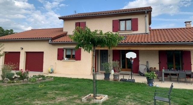 Une grande maison aux volets rouge bordeau.