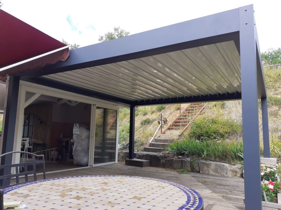 Une pergola d'une maison à proximité d'un escalier.