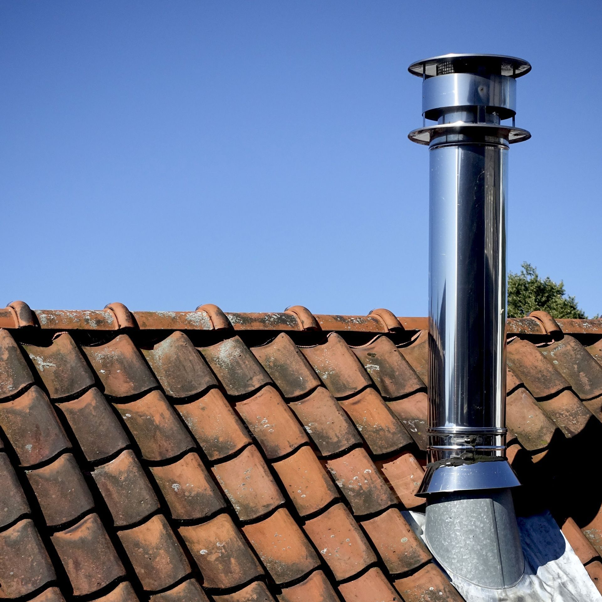 Un toit en tuiles avec un conduit en inox