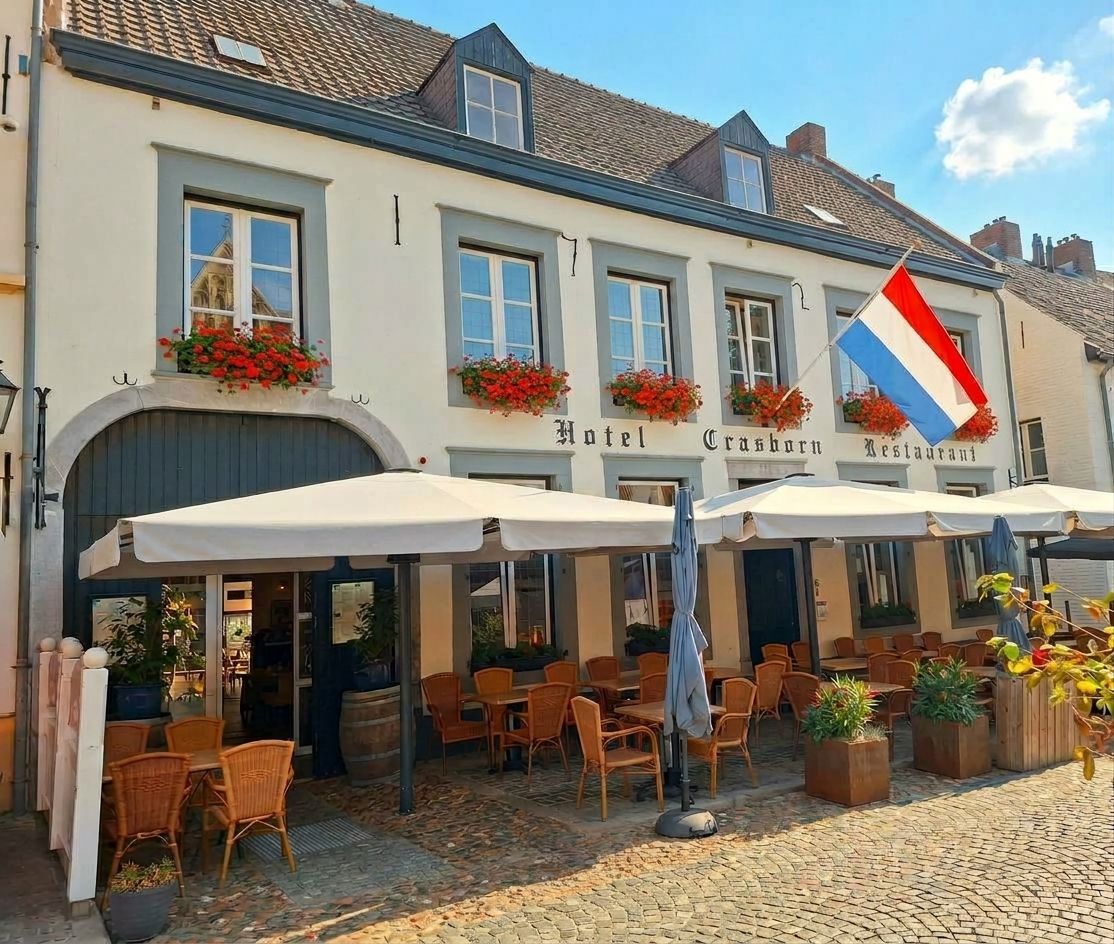 Een restaurant met tafels en parasols ervoor