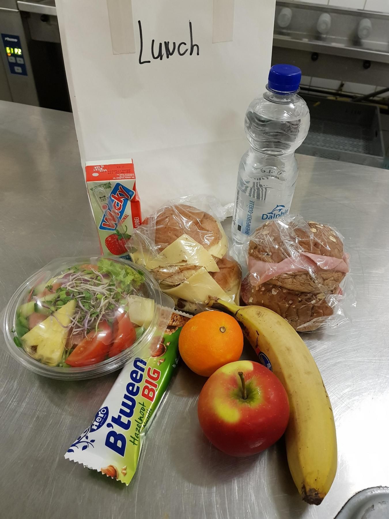 Een lunchtas gevuld met eten en een fles water