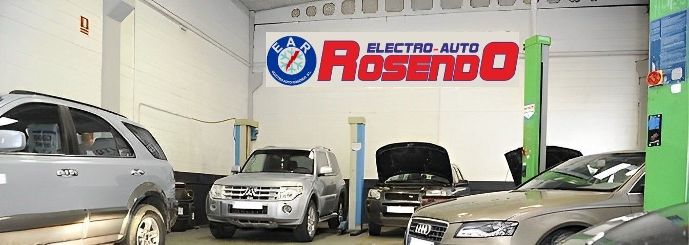 Varios coches están aparcados en un garaje con un cartel que dice rosendo
