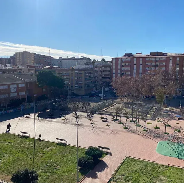 Una vista aérea de un parque en una ciudad con edificios al fondo.
