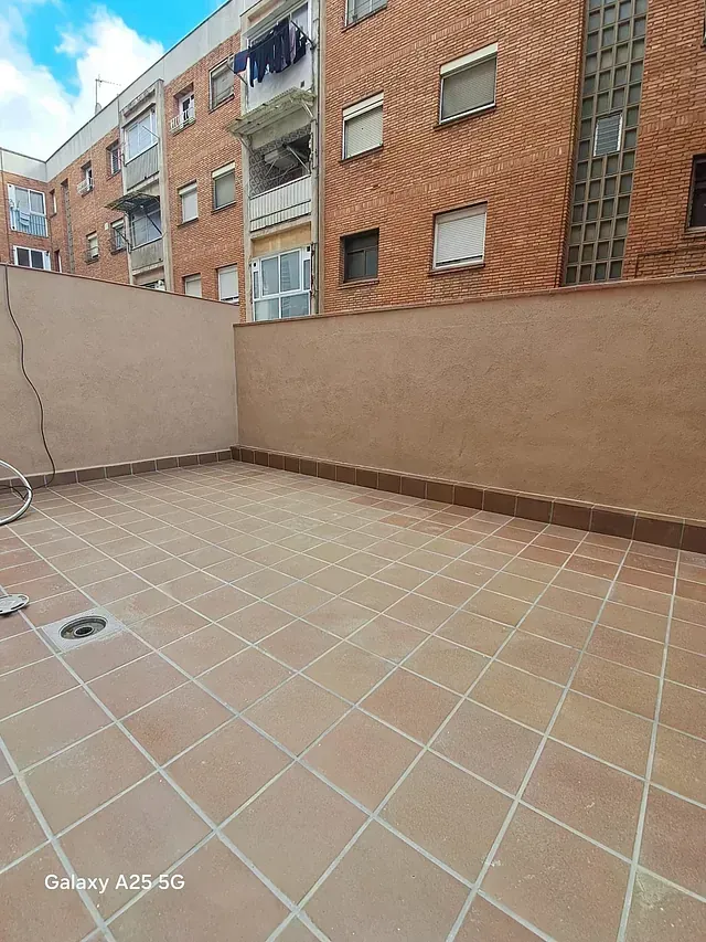 Un edificio de ladrillo con un piso de baldosas en el frente.