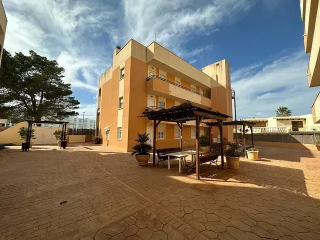 Un gran edificio con una pérgola delante.