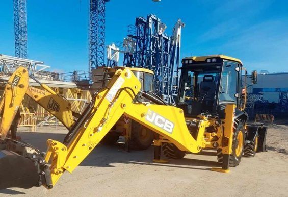 Una retroexcavadora JCB amarilla está estacionada en un estacionamiento.