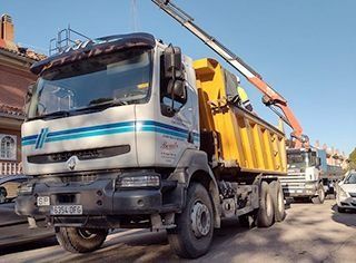 Un camión volquete con una grúa acoplada