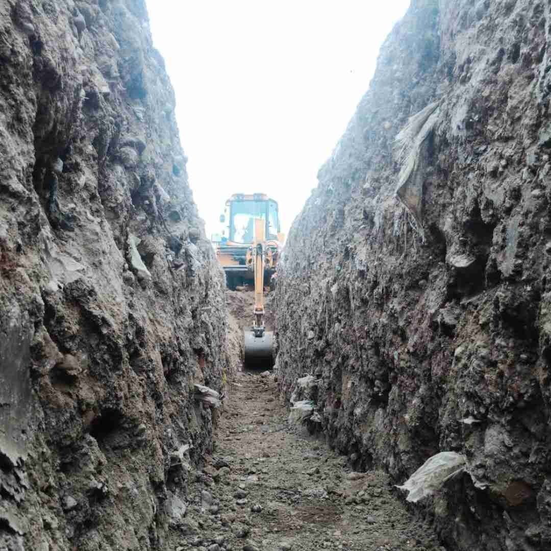Una excavadora está cavando una zanja en el suelo.