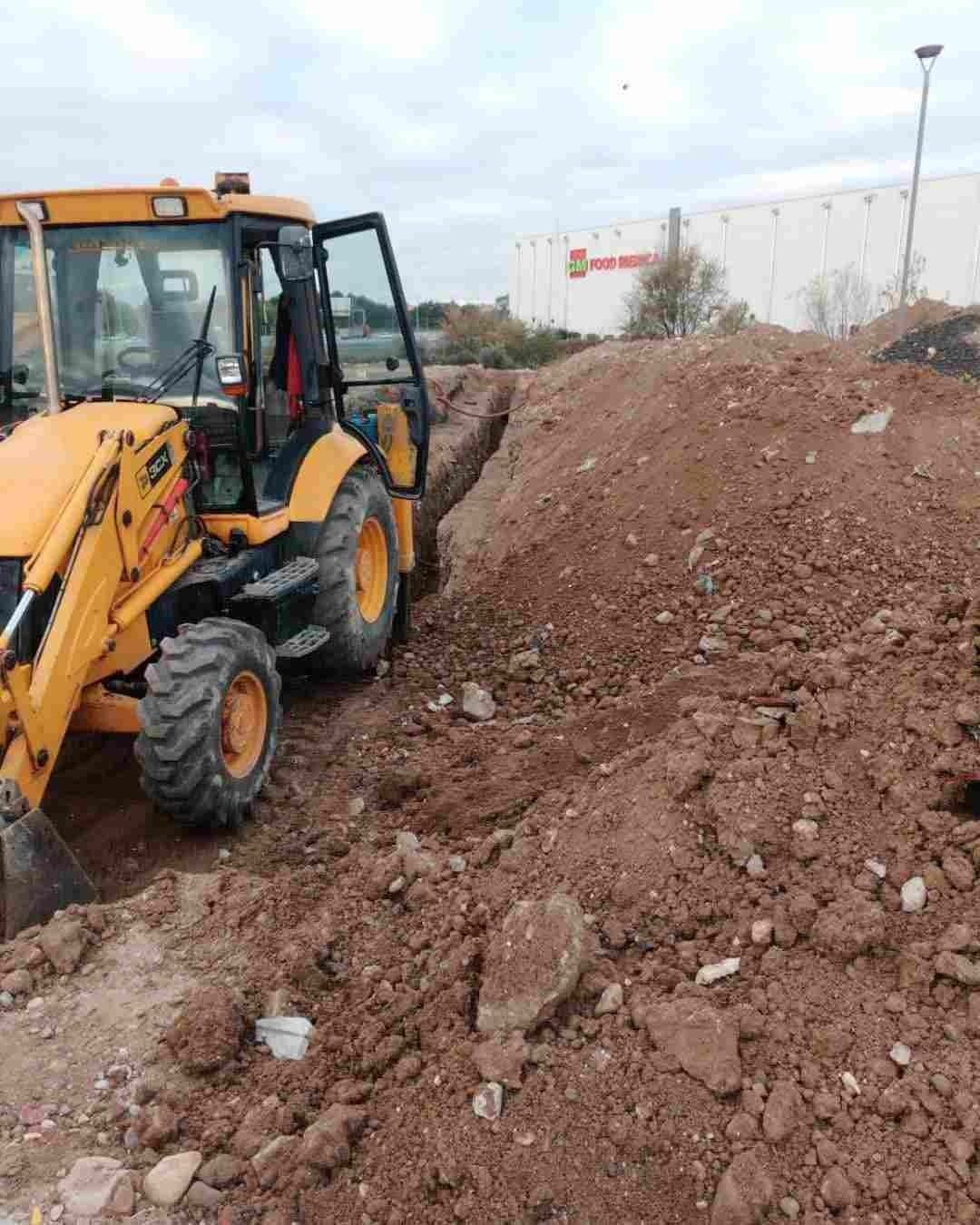 Un tractor amarillo está sentado encima de un montón de tierra.