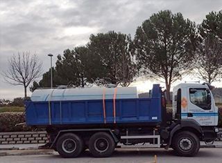 Un camión volquete azul está estacionado al costado de la carretera