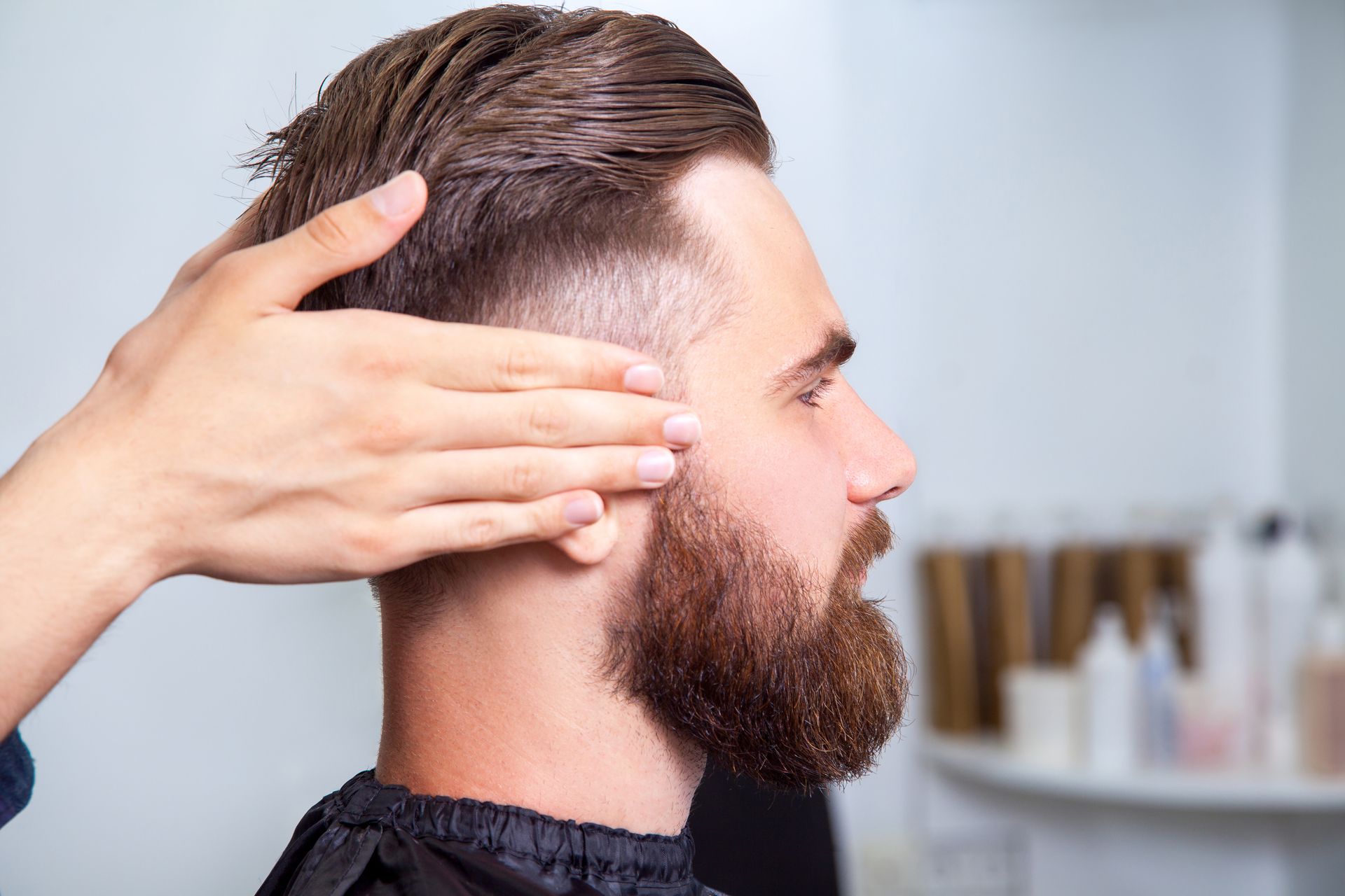 Mains sur les tempes d'un homme avec une barbe